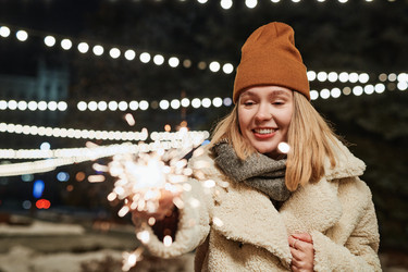 Молодая женщина держит в руках Sparkler - Mediaphotos