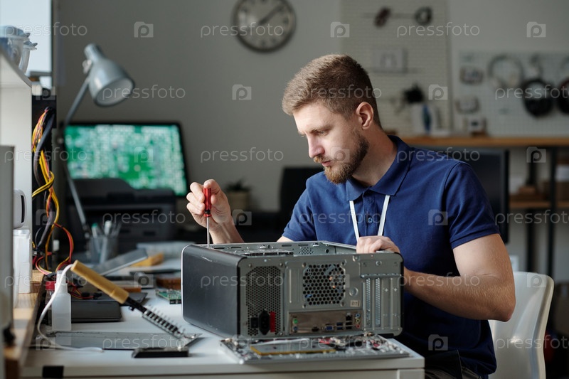 Молодой серьезный техник на работе