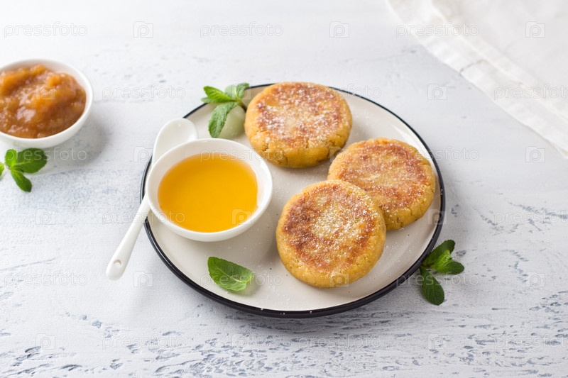 Чизкейки с тофу и бананом, тофники, с медом и посыпанные сахарной пудрой, украшенные мятой на светло-голубом фоне, вид сверху. Вкусная веганская еда