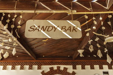 Вывеска бара Sandy Bar, подвешенная к деревянному потолку и украшенная ракушками, в Марса-Аламе, Египет - Pippocarlot