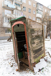Ветхая деревянная уборная в заснеженном дворе городского многоквартирного дома. Символ городского упадка и нищеты - AliakseiSmalenski