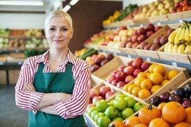 Портрет взрослой женщины, стоящей в отделе овощей и фруктов в продуктовом магазине. - SeventyFour