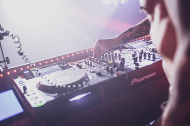 Профессиональный диджей микширует музыку на контроллере Pioneer в ночном клубе - Pippocarlot