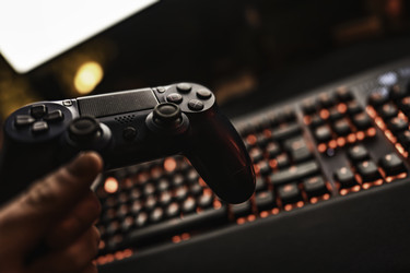 Игрок держит контроллер PlayStation и игровую клавиатуру - Pippocarlot