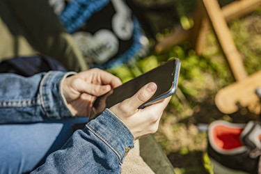 Молодая женщина пользуется смартфоном на улице - Pippocarlot