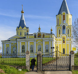 Желтый православный храм Успения Пресвятой Богородицы (Успенская церковь) с двумя колокольнями и куполами в сельском пейзаже. Лихославль, Тверская область - Sadoff