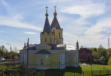 Желтый православный храм Успения Пресвятой Богородицы (Успенская церковь) с двумя колокольнями и куполами в сельском пейзаже. Лихославль, Тверская область - Sadoff