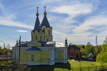 Желтый православный храм Успения Пресвятой Богородицы (Успенская церковь) с двумя колокольнями и куполами в сельском пейзаже. Лихославль, Тверская область - Sadoff