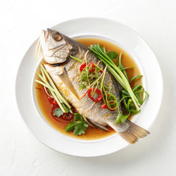 Вкуснейшая китайская рыба, приготовленная на пару, подается со свежей зеленью и специями на белой тарелке. Генеративный искусственный интеллект - RomanZ