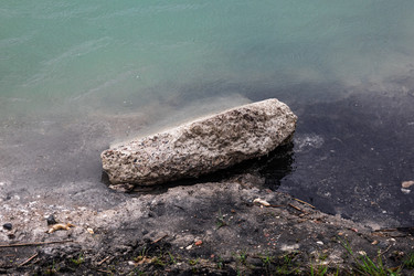 Большой камень на берегу озера у кромки воды - Derbis