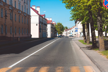 Гродно, Беларусь - 1 мая 2025 года: Городская улица. Городской пейзаж под ярко-голубым небом - steveee