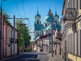 Гродно, Беларусь - 1 мая 2025 года: Городская улица. Городской пейзаж под ярко-голубым небом - steveee