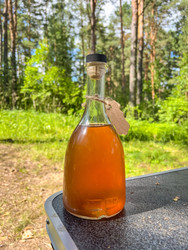 Прозрачная стеклянная бутылка с жидкостью янтарного цвета, пробковая пробка - steveee