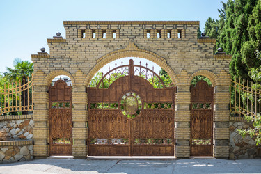 Красивые кованые ворота в кирпичной арке на природе - paha_l