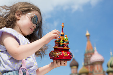 Маленькая девочка в солнцезащитных очках и подтяжках на фоне миниатюрного собора возле Кремля - paha_l