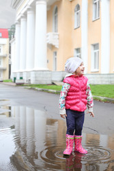 Счастливая девочка в яркой одежде стоит в луже - paha_l
