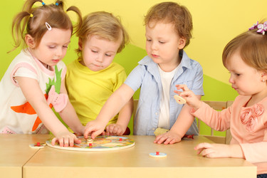 Два мальчика и две девочки вместе собирают деревянный пазл - paha_l