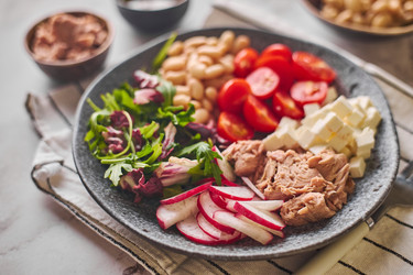 Полезный салат из тунца с белой фасолью, сыром фета, помидорами, редисом и зеленью на мраморном столе - Irrin0215