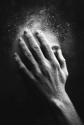 Потрясающий крупный план, демонстрирующий руку, нежно выпускающую сверкающие частицы под мягким теплым светом - Neirfy