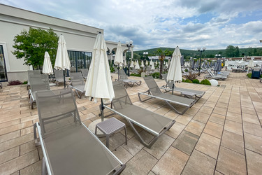 Empty furniture sunbeds and umbrellas on pool terrace at spa paradise resort hotel outdoor exterior on cloudy summer day - Matroskin