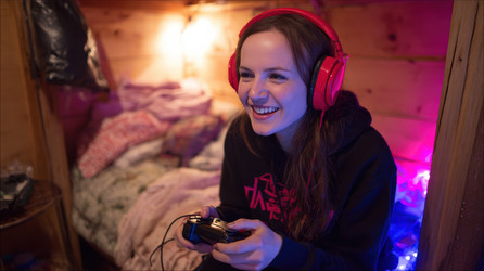 Восторженный геймер в наушниках, увлеченно играющий в видеоигры - Neirfy