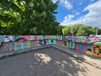 Яркие рисунки и граффити на бетонном парапете в парковой зоне города - arshinec