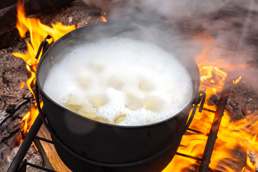 Горшок, полный вкуснейших пельменей, кипящих на пылающем огне — такой восхитительный запах, что все сбегаются, чтобы насладиться горячей едой - dkorostilev78