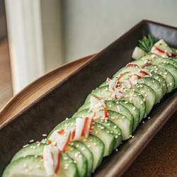 Салат из нарезанных огурцов, украшенный крабовым мясом и кунжутом, на стандартной тарелке. Генеративный искусственный интеллект - RomanZ