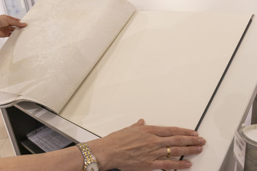 Покупатель просматривает каталог обоев в выставочном зале современного дизайна интерьеров. Интерьер - Pazemin