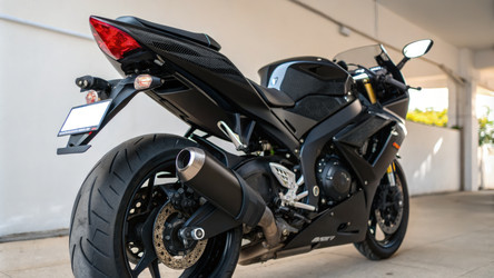 Мотоцикл Suzuki GSX-R в элегантном черном цвете припаркован в современном гараже. Генеративный искусственный интеллект - RomanZ