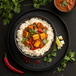 Вкусный панир чили, подаваемый с рисом на черной тарелке. Генеративный искусственный интеллект - RomanZ