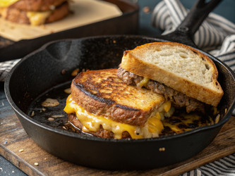 Крупный план аппетитного сэндвича «Патти Мелт», готовящегося на чугунной сковороде. Генеративный ИИ - RomanZ