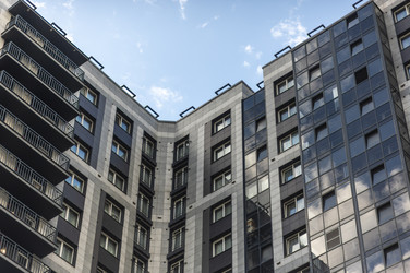 Высотное жилое здание, Санкт-Петербург, июнь 2026 года, современное, со стеклянными фасадами, возвышающееся на фоне впечатляющего летнего облачного неба с голубыми просветами - Kulkann75