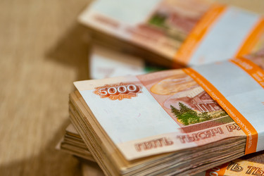 Крупные российские банкноты в пачке лежат на столе - dkorostilev78