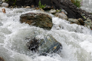 Вода бурной горной реки разбивается о валун в русле реки - kostya6969