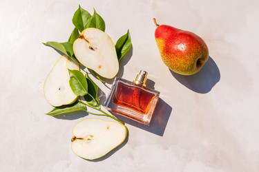 Элегантный флакон духов с ароматом спелой груши на светлом мраморном фоне с ломтиками груши. Вид сверху. Тень от солнца. Макет пустого флакона - MarinaMos