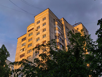 Архитектура в свете заката — уют городских улиц. Пейзажный снимок жилого многоэтажного здания в вечернее время - DaniilAlexiy