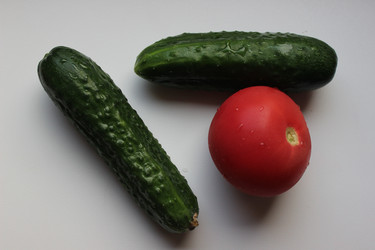 Огурцы и помидор с каплями воды на белом подоконнике, вид сверху - AleksSu