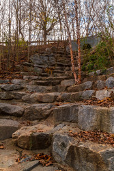 Грубые каменные ступени и заросли голых деревьев на тропе Wetlands Trail в парке Piedmont Park осенним днем, Атланта, США - DrVerner