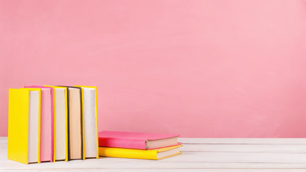 Разноцветная стопка книг на деревянном столе на розовом фоне. Генеративный ИИ - RomanZ
