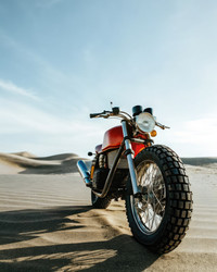 Мотоцикл Ducati Cafe Racer припаркован в пустынных песках под ярким небом. Генеративный искусственный интеллект - RomanZ