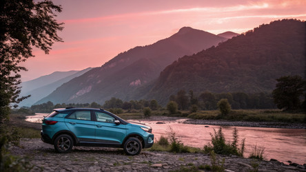Автомобиль Tata Nexon припаркован у реки на фоне гор и заката. Генеративный ИИ - RomanZ