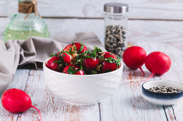 Вкусная закуска из размятой маринованной редьки с зеленью в миске на столе - Elena Rui