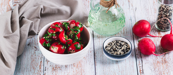 Вкусная закуска из размятой маринованной редьки с зеленью в миске на столе (веб-баннер) - Elena Rui