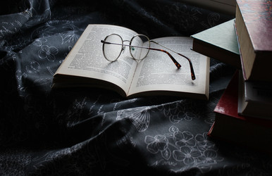 Стопка книг и очки на раскрытой книге, глубокие тени - AleksSu