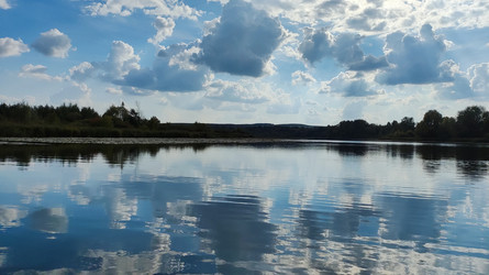 Спокойная гладь озера под высоким облачным небом - Kireburi