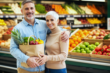 Портрет супружеской пары среднего возраста, совершающей покупки продуктов для здорового образа жизни. - SeventyFour
