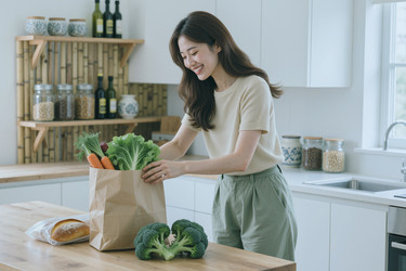Взрослая азиатская женщина распаковывает свежие продукты для приготовления здоровой домашней еды. - SeventyFour