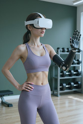 Взрослая женщина с протезом руки использует vr для фитнес-тренировок. - SeventyFour