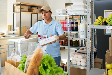 Испаноязычная женщина готовит продуктовый заказ для доставки еды - Pressmaster